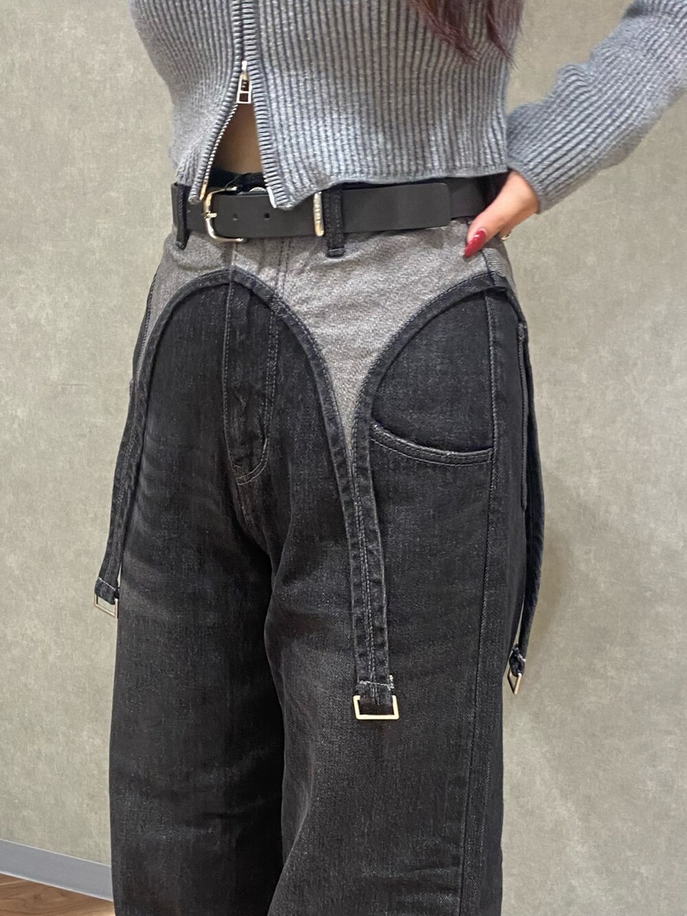 グレー系のニット/セーター、ブラック系のデニムパンツ、ブラック系のブーツを着用したレディースの秋コーディネートの7枚目の写真