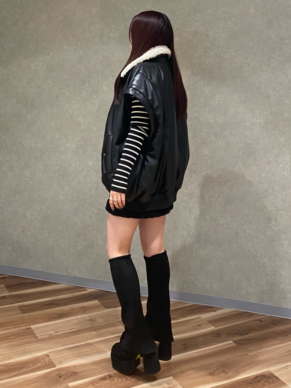 ブラック系のブルゾン、ブラック系のニット/セーター、ブラック系のスカートを着用したレディースの秋コーディネートの3枚目の写真