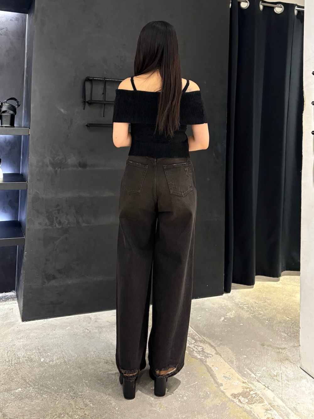 ブラック系のデニムパンツ、ブラック系のサンダル、ブラック系のニット/セーターを着用したレディースの夏コーディネートの3枚目の写真