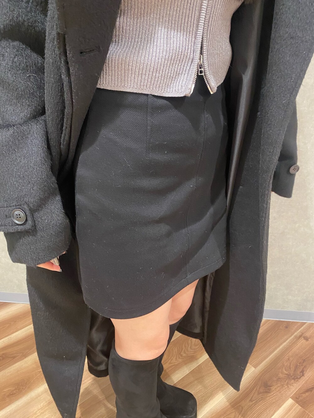 シルバー系のニット/セーター、ブラック系のブーツ、ブラック系のその他アウターを着用したレディースの冬コーディネートの6枚目の写真