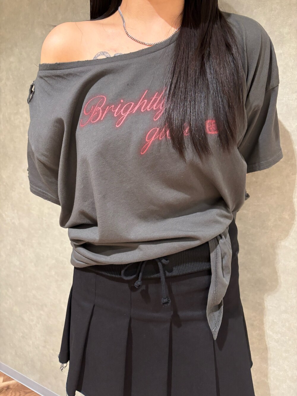 ブラック系のスカート、グレー系のTシャツ/カットソー、ブラック系のサンダルを着用したレディースの春コーディネートの5枚目の写真