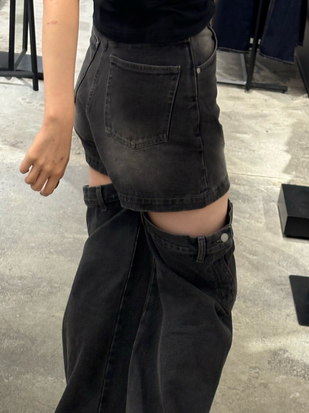 ブラック系のデニムパンツ、ブラック系のサンダル、ホワイト系のTシャツ/カットソーを着用したレディースの夏コーディネートの5枚目の写真