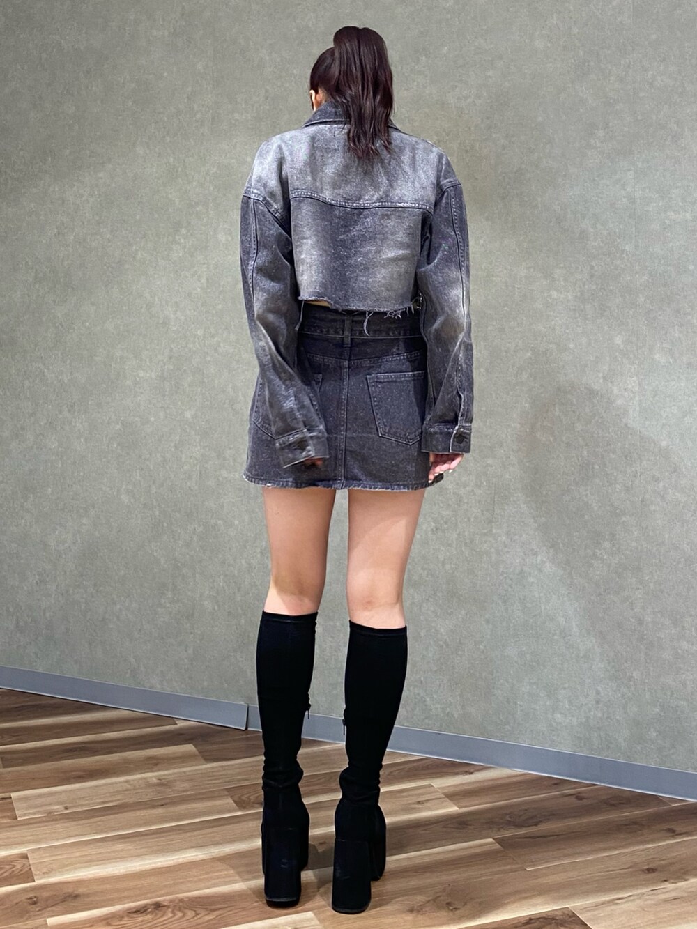 ブラック系のデニムジャケット、ホワイト系のニット/セーター、ブラック系のデニムスカートを着用したレディースの秋コーディネートの4枚目の写真