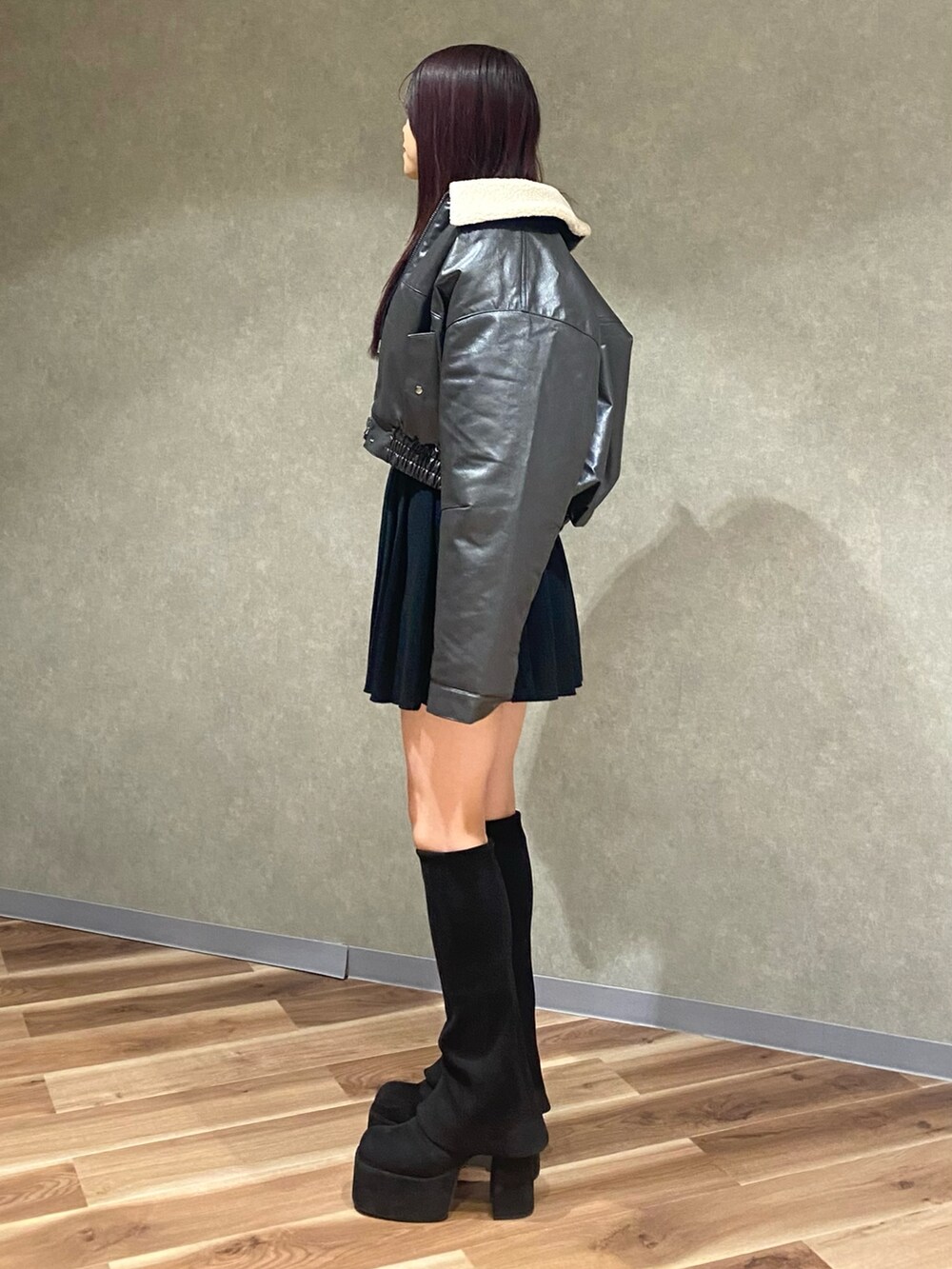 グレー系のブルゾン、ブラック系のニット/セーター、ブラック系のスカートを着用したレディースの秋コーディネートの4枚目の写真