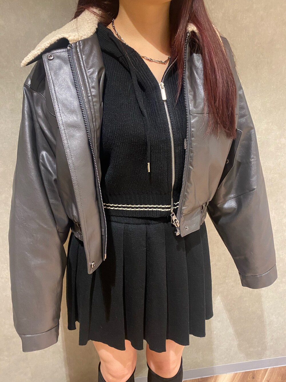 グレー系のブルゾン、ブラック系のニット/セーター、ブラック系のスカートを着用したレディースの秋コーディネートの5枚目の写真