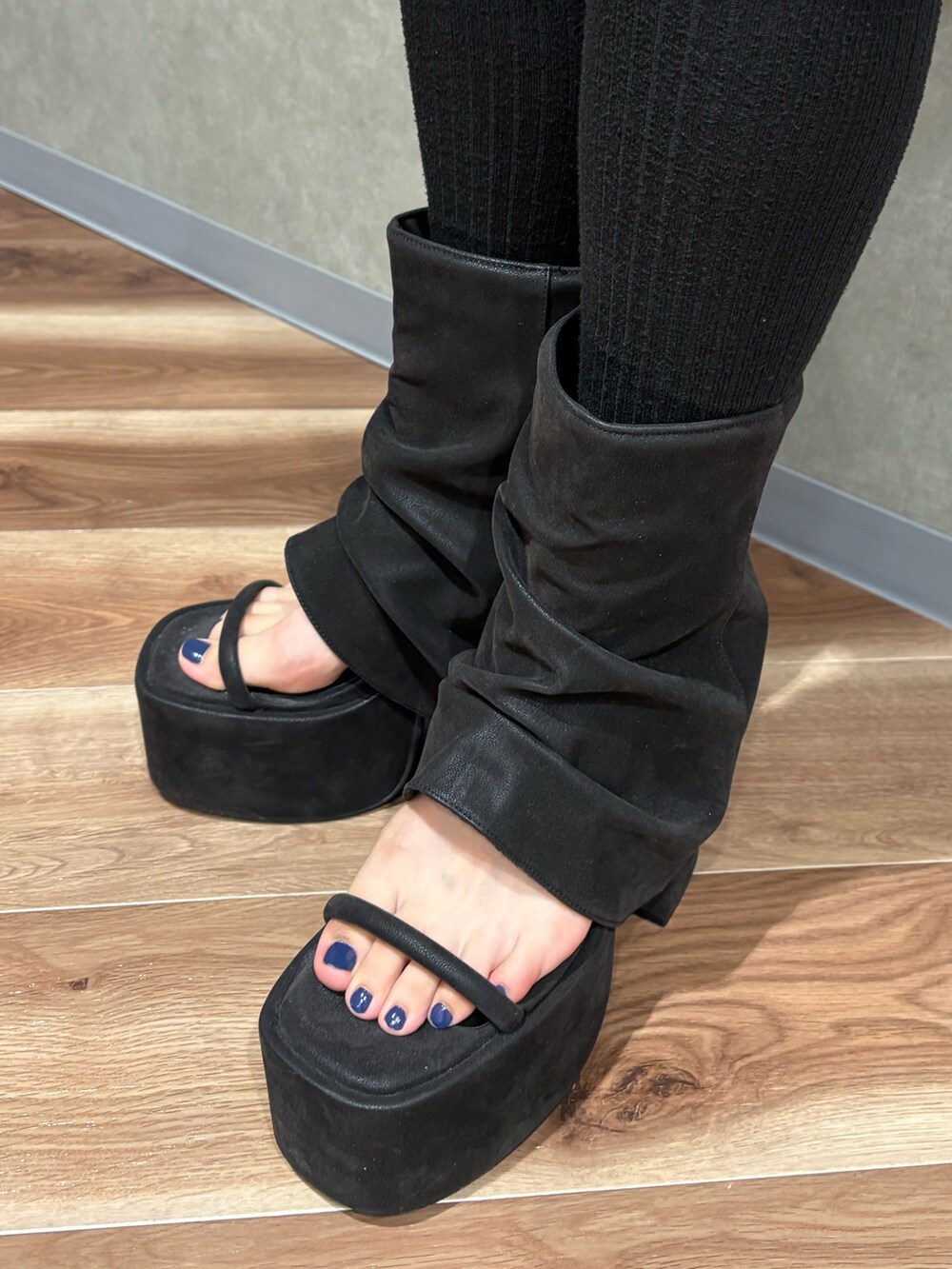 ブラック系のスカート、グレー系のTシャツ/カットソー、ブラック系のサンダルを着用したレディースの春コーディネートの7枚目の写真