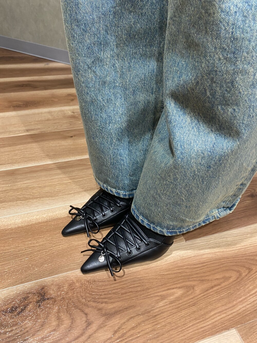 ブルー系のデニムパンツ、ブラック系のシャツ/ブラウス、ブラック系のパンプスを着用したレディースの春コーディネートの7枚目の写真