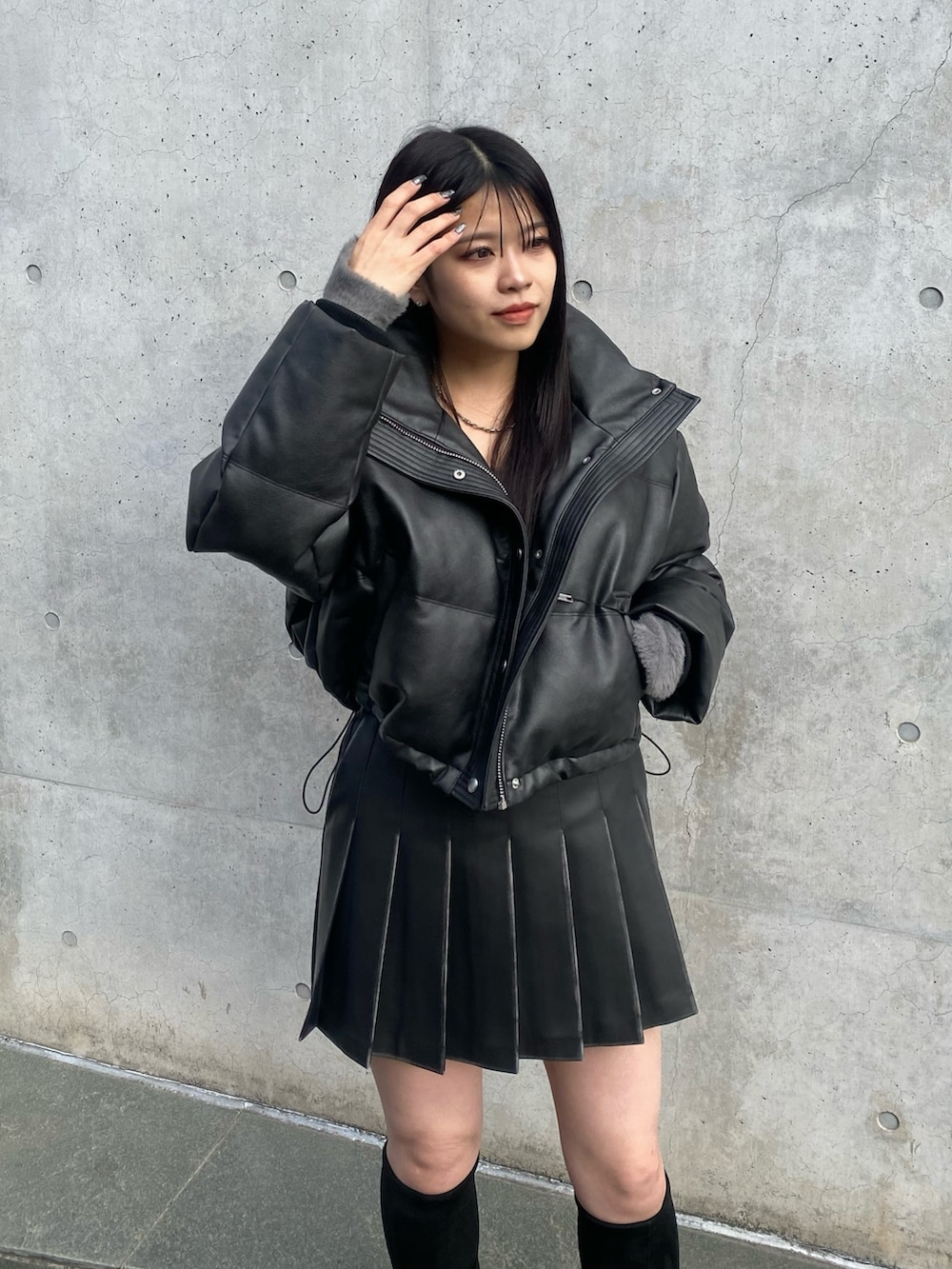 ブラック系のブーツ、ブラック系のスカート、ブラック系のダウンジャケット/コートを着用したレディースの冬コーディネートの5枚目の写真