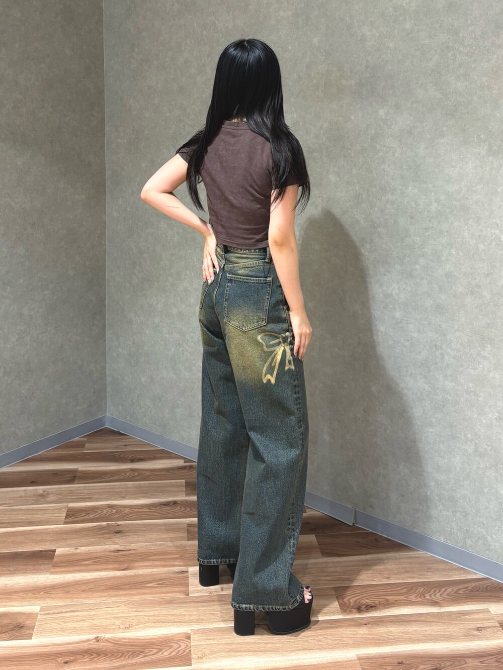 ブルー系のデニムパンツ、ブラウン系のTシャツ/カットソー、ブラック系のサンダルを着用したレディースの夏コーディネートの3枚目の写真