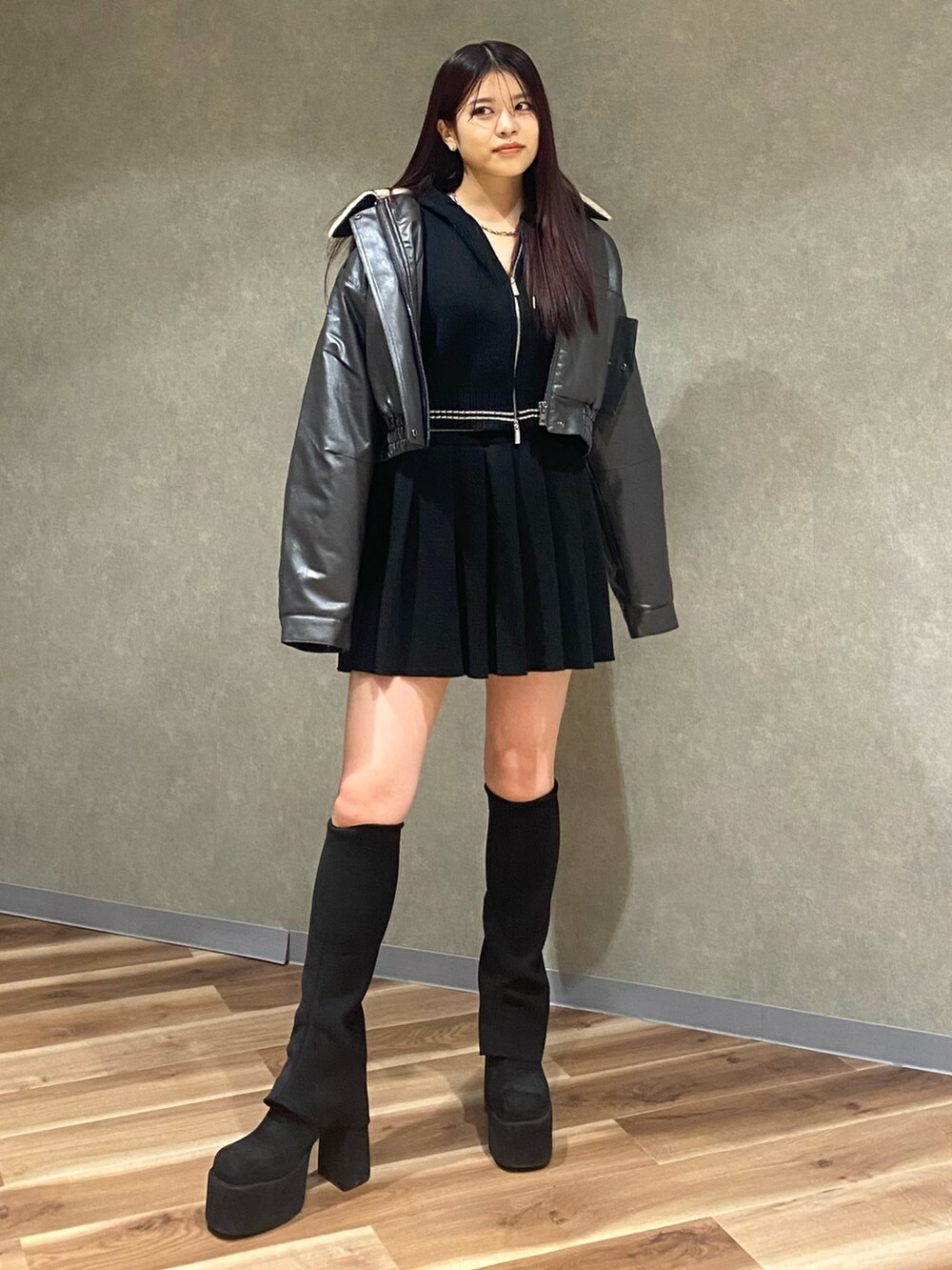 グレー系のブルゾン、ブラック系のニット/セーター、ブラック系のスカートを着用したレディースの秋コーディネートの2枚目の写真