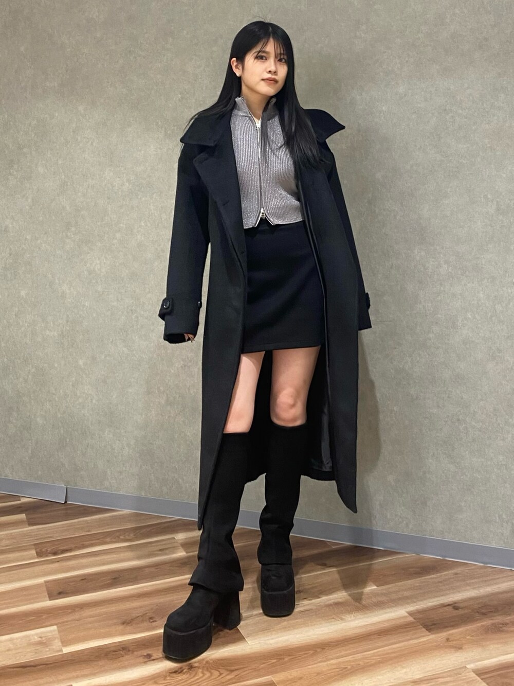 シルバー系のニット/セーター、ブラック系のブーツ、ブラック系のその他アウターを着用したレディースの冬コーディネートの2枚目の写真