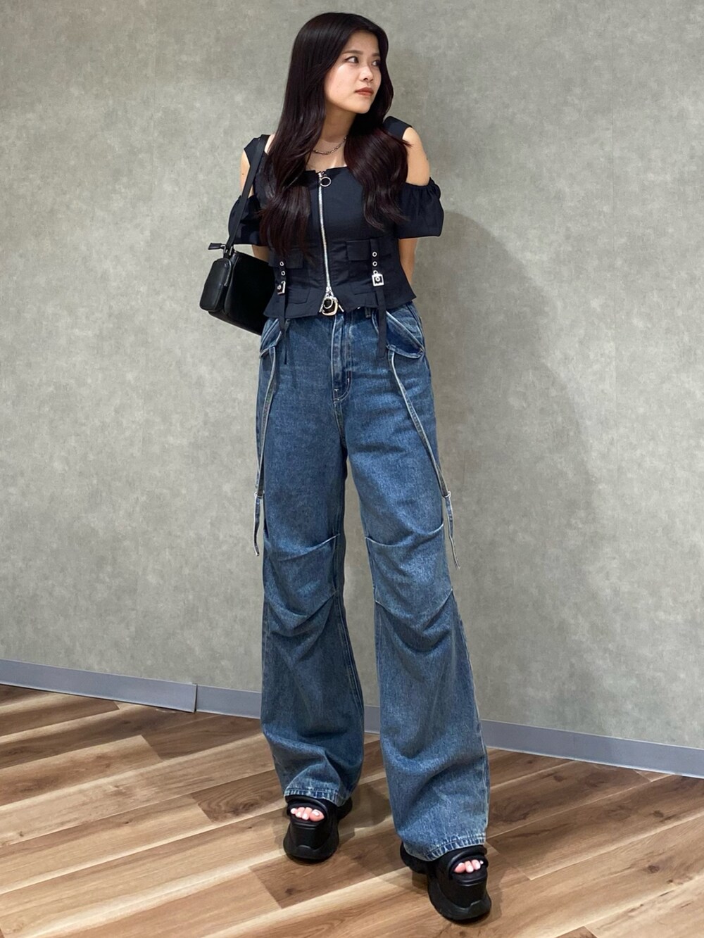 ブルー系のデニムパンツ、ブラック系のショルダーバッグ、ブラック系のTシャツ/カットソーを着用したレディースの夏コーディネートの2枚目の写真