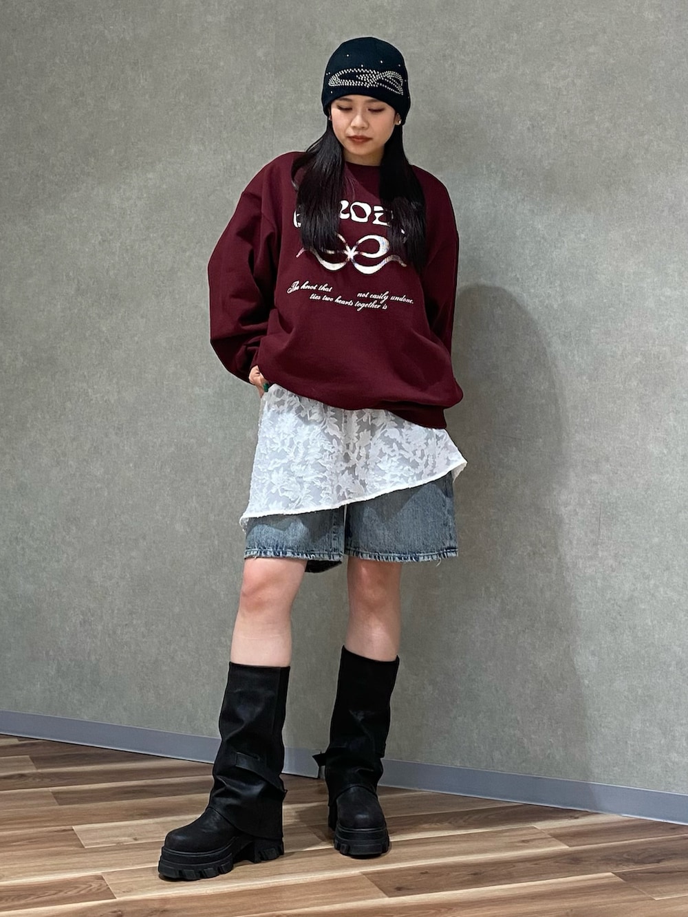 ホワイト系のスカート、ブルー系のデニムパンツ、ブラック系のブーツを着用したレディースの冬コーディネートの2枚目の写真