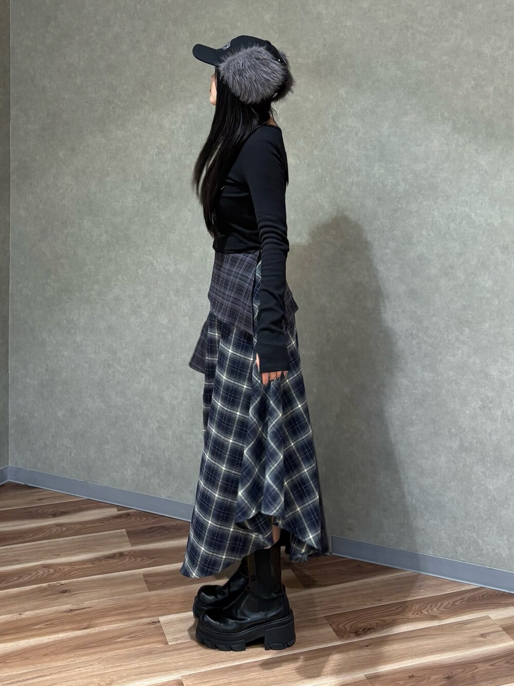 ブラック系のTシャツ/カットソー、ブルー系のスカート、ブラック系のブーツを着用したレディースの秋コーディネートの2枚目の写真