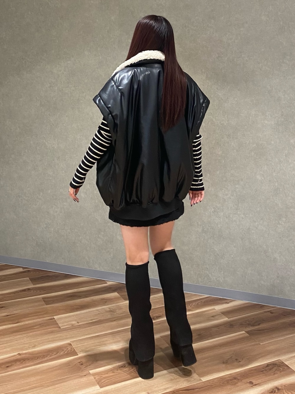 ブラック系のブルゾン、ブラック系のニット/セーター、ブラック系のスカートを着用したレディースの秋コーディネートの4枚目の写真