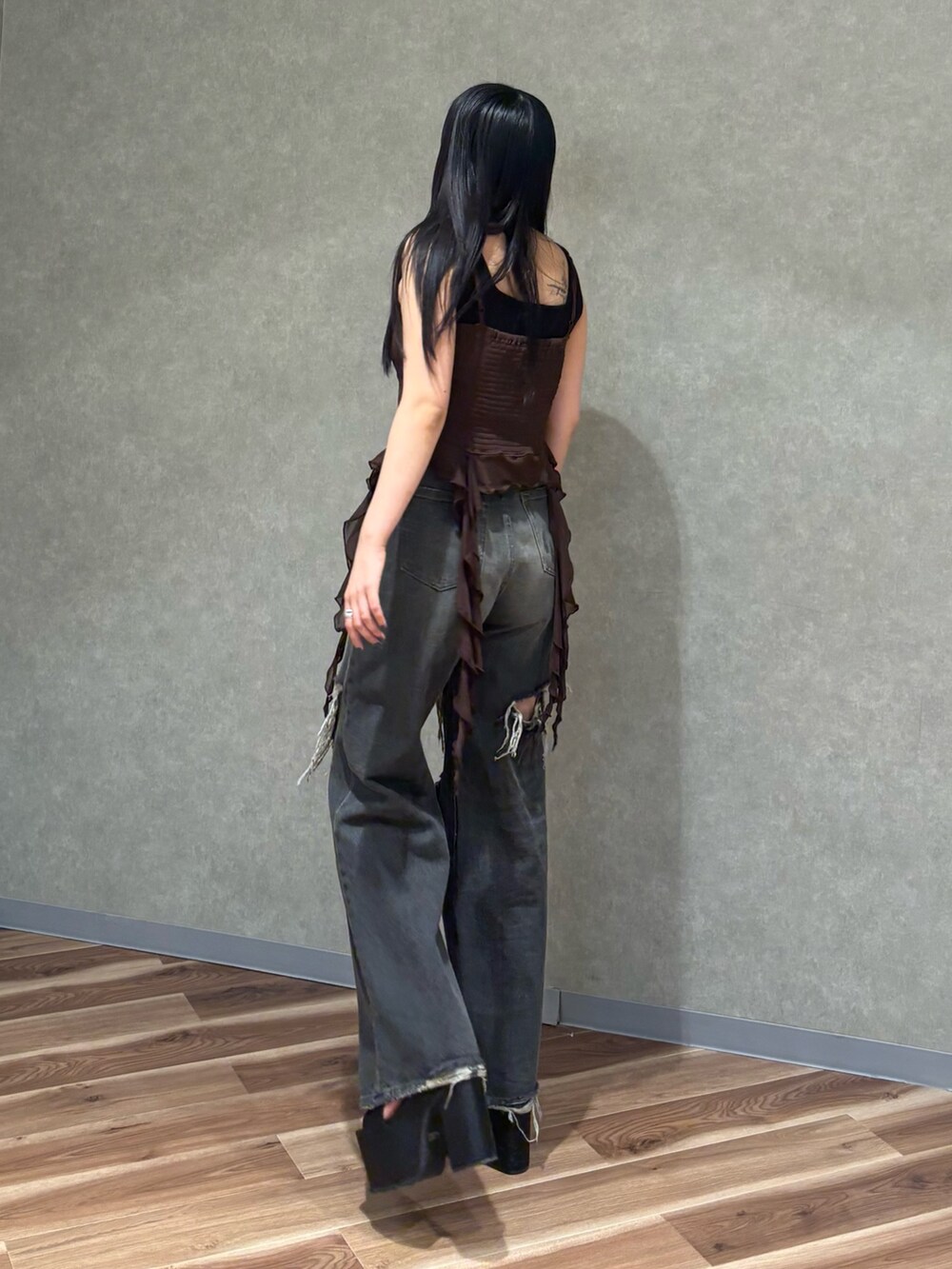 ブラック系のデニムパンツ、ブラック系のサンダル、ブラウン系のTシャツ/カットソーを着用したレディースの春コーディネートの3枚目の写真