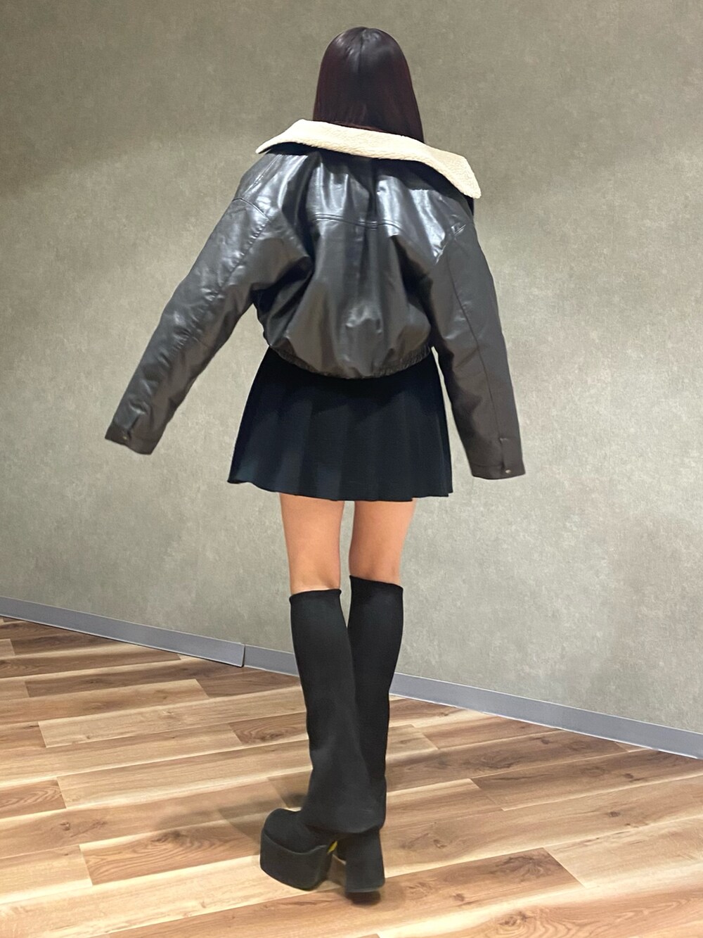 グレー系のブルゾン、ブラック系のニット/セーター、ブラック系のスカートを着用したレディースの秋コーディネートの3枚目の写真