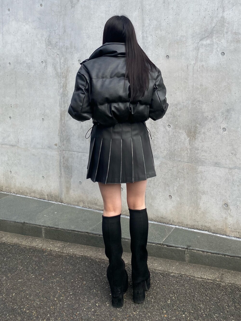 ブラック系のブーツ、ブラック系のスカート、ブラック系のダウンジャケット/コートを着用したレディースの冬コーディネートの4枚目の写真