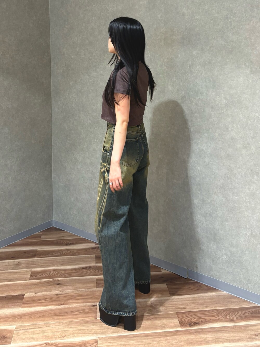 ブルー系のデニムパンツ、ブラウン系のTシャツ/カットソー、ブラック系のサンダルを着用したレディースの夏コーディネートの2枚目の写真