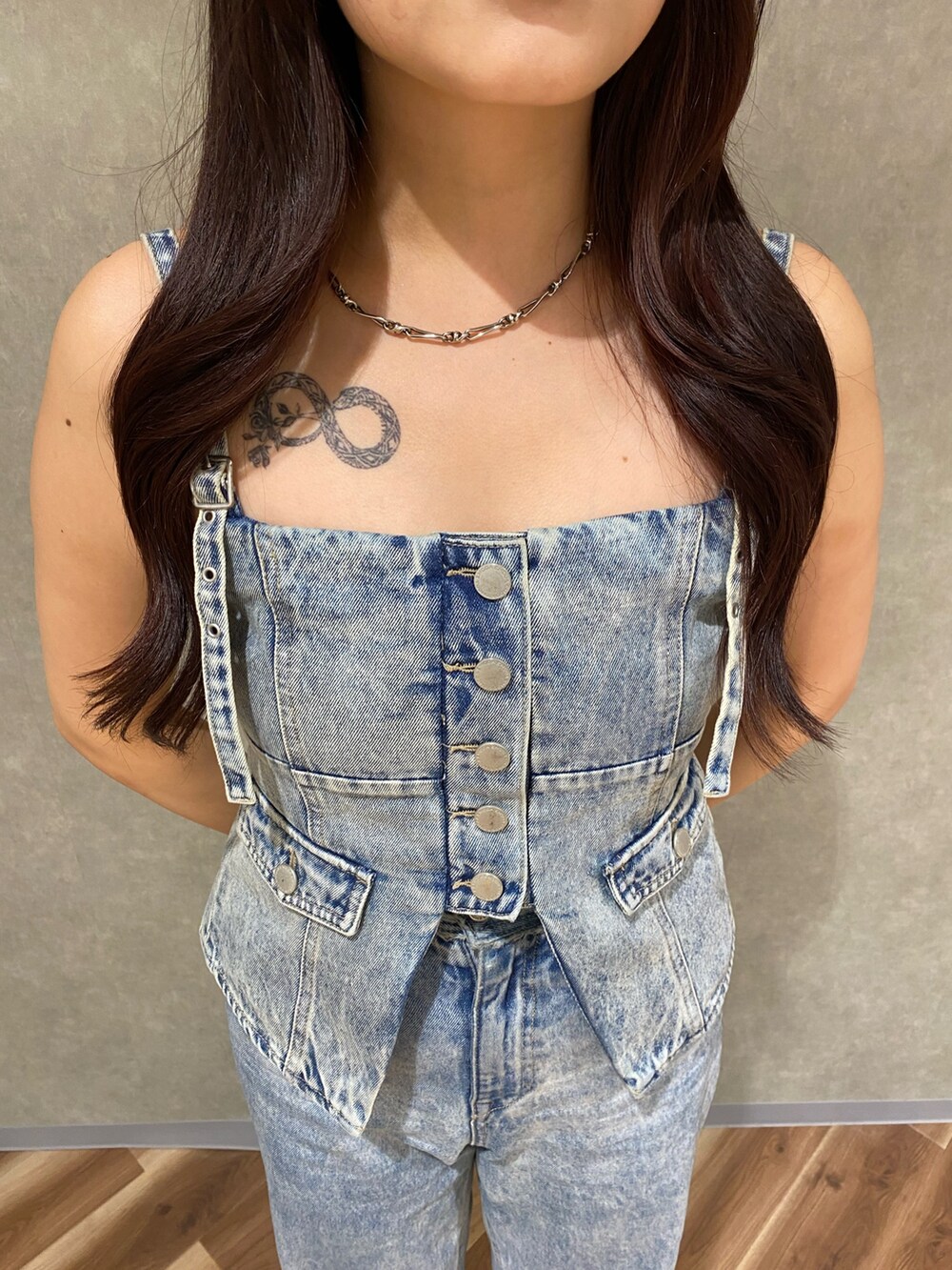 ブルー系のデニムパンツ、ブルー系のキャミソール、シルバー系のハンドバッグを着用したレディースの夏コーディネートの5枚目の写真