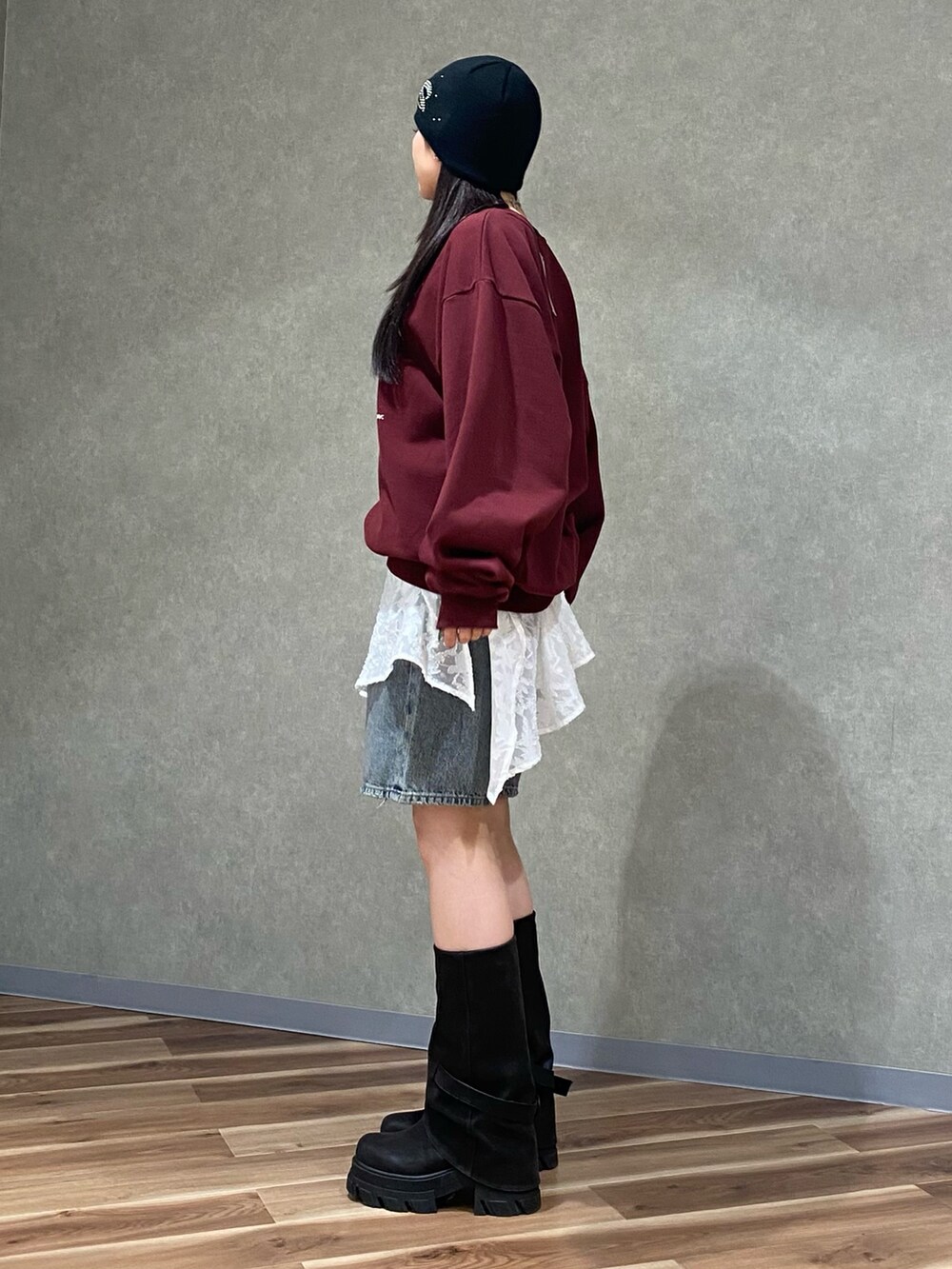 ホワイト系のスカート、ブルー系のデニムパンツ、ブラック系のブーツを着用したレディースの冬コーディネートの3枚目の写真