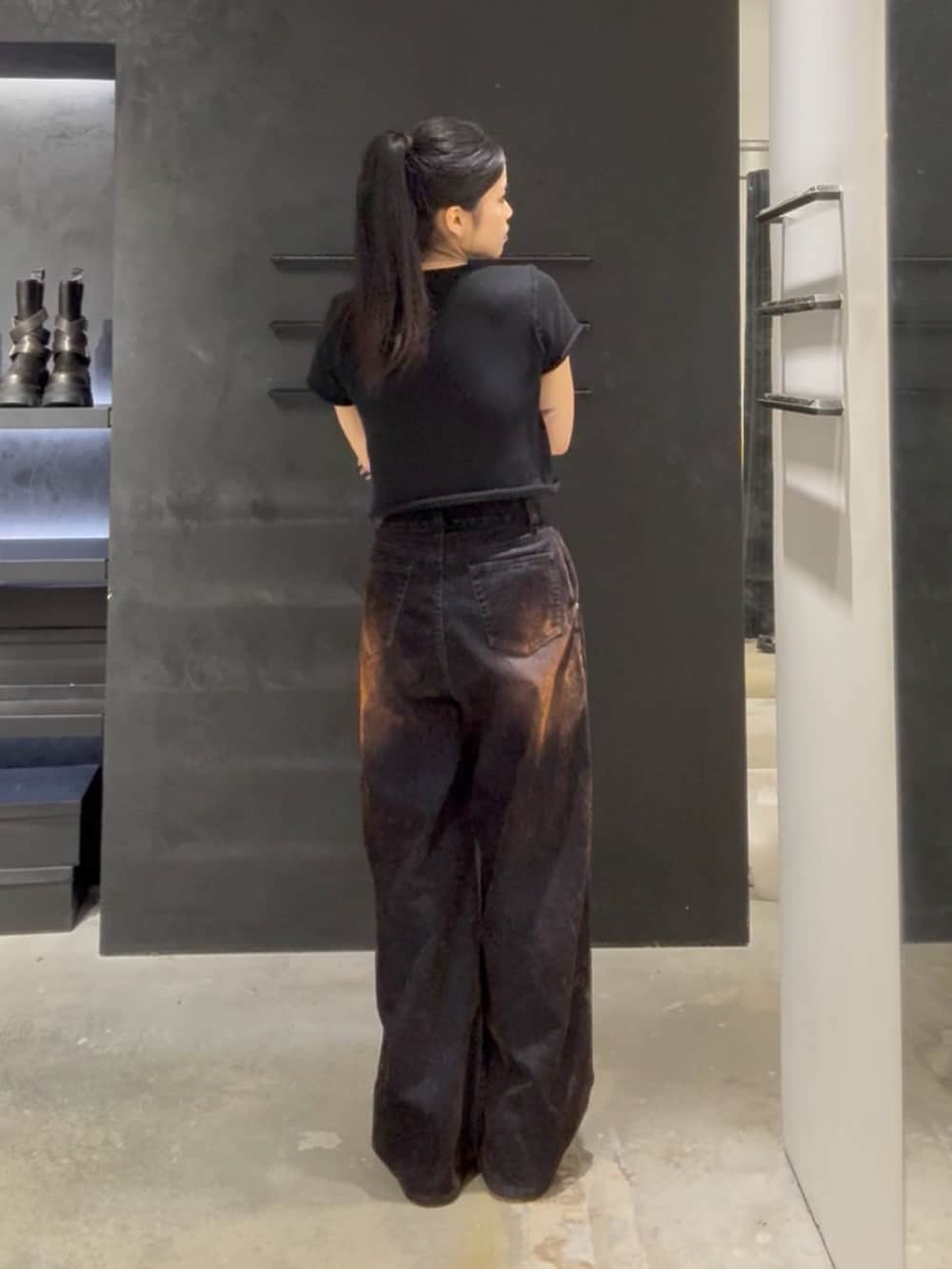 ブラック系のニット/セーター、ブラウン系のデニムパンツ、イエロー系のスリッポンを着用したレディースの夏コーディネートの3枚目の写真