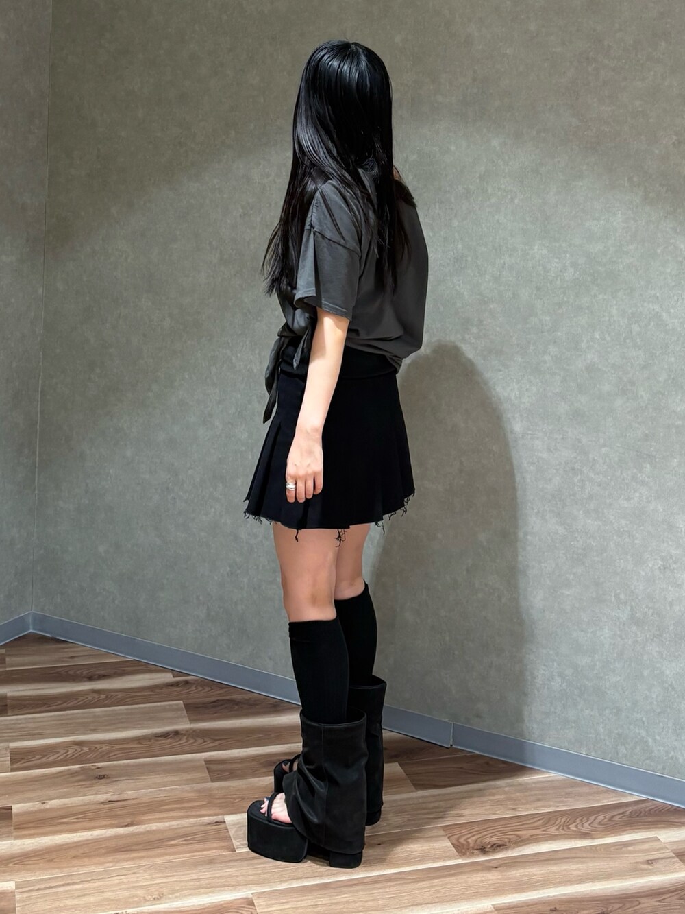 ブラック系のスカート、グレー系のTシャツ/カットソー、ブラック系のサンダルを着用したレディースの春コーディネートの3枚目の写真