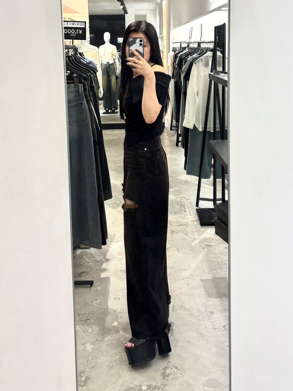 ブラック系のデニムパンツ、ブラック系のサンダル、ブラック系のニット/セーターを着用したレディースの夏コーディネートの2枚目の写真