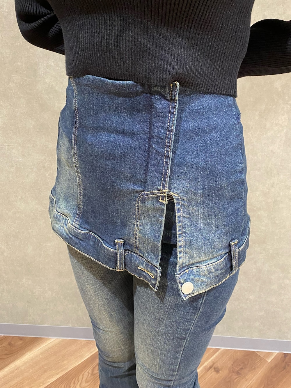 ブラック系のニット/セーター、ブルー系のデニムパンツ、ブラック系のブーツを着用したレディースの秋コーディネートの8枚目の写真