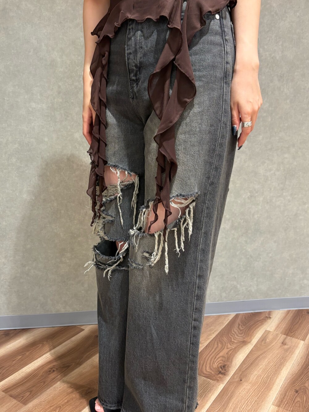 ブラック系のデニムパンツ、ブラック系のサンダル、ブラウン系のTシャツ/カットソーを着用したレディースの春コーディネートの6枚目の写真