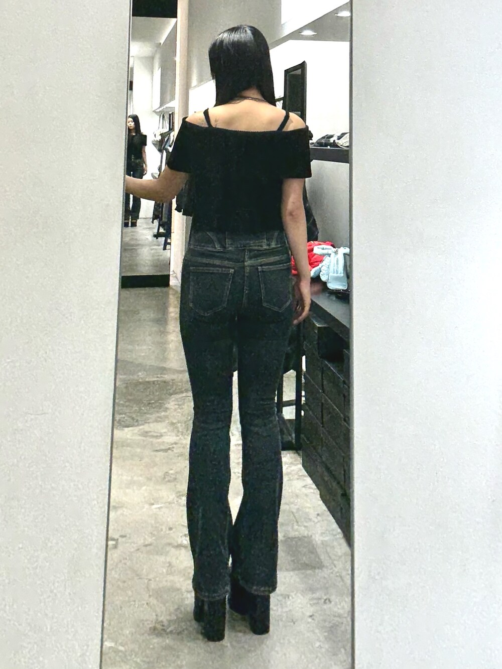 ブルー系のデニムパンツ、ブラック系のニット/セーター、ブラック系のサンダルを着用したレディースの夏コーディネートの3枚目の写真