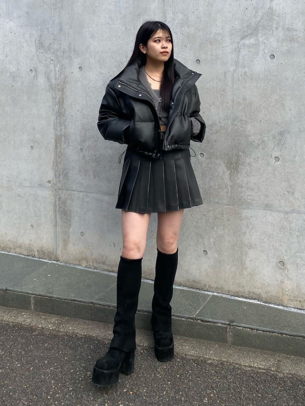 ブラック系のブーツ、ブラック系のスカート、ブラック系のダウンジャケット/コートを着用したレディースの冬コーディネートの2枚目の写真