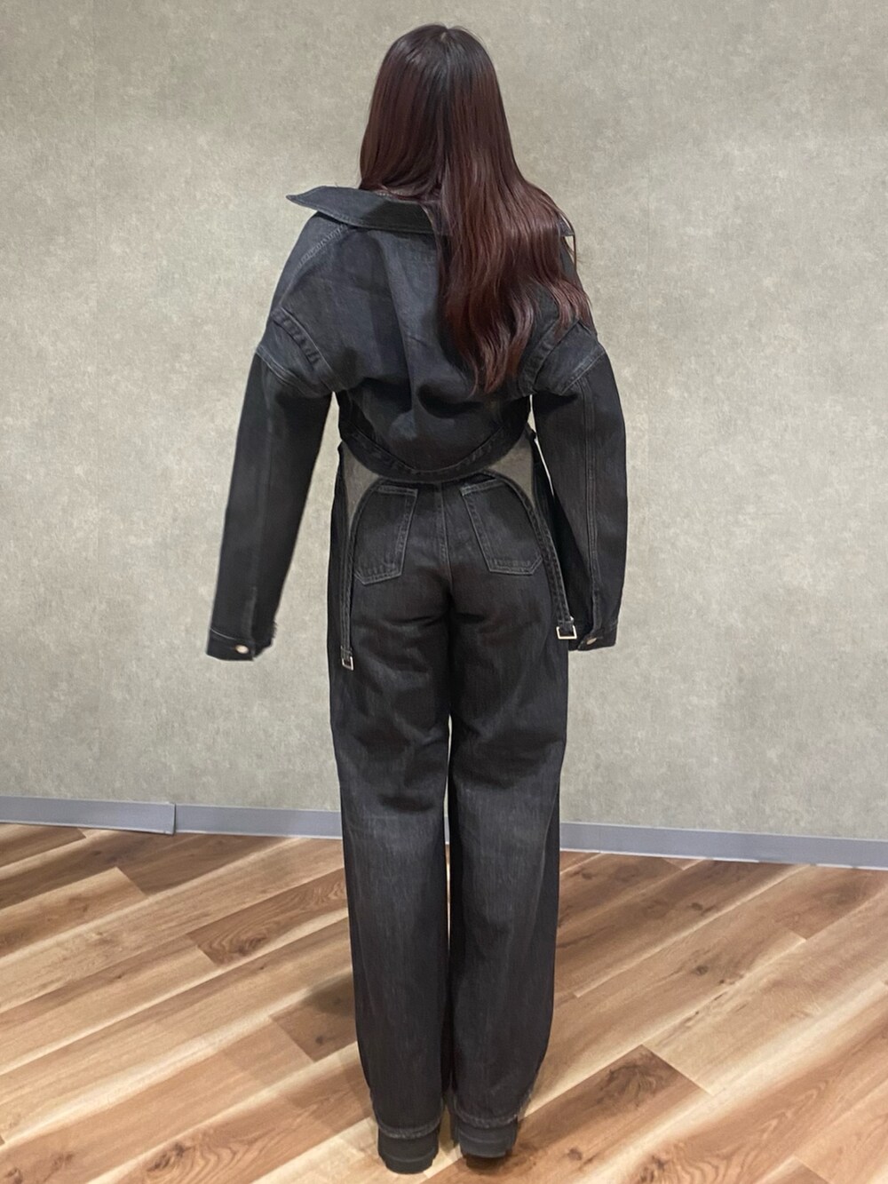 グレー系のニット/セーター、ブラック系のデニムパンツ、ブラック系のブーツを着用したレディースの秋コーディネートの5枚目の写真