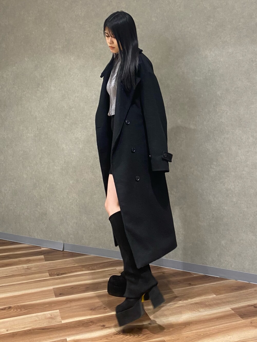 シルバー系のニット/セーター、ブラック系のブーツ、ブラック系のその他アウターを着用したレディースの冬コーディネートの3枚目の写真