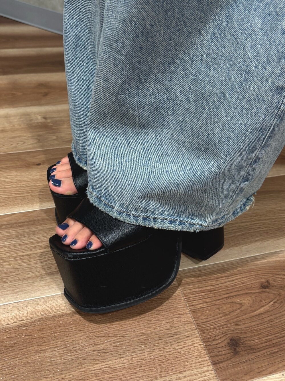 ブルー系のデニムパンツ、ブラック系のサンダル、ブラック系のTシャツ/カットソーを着用したレディースの夏コーディネートの7枚目の写真