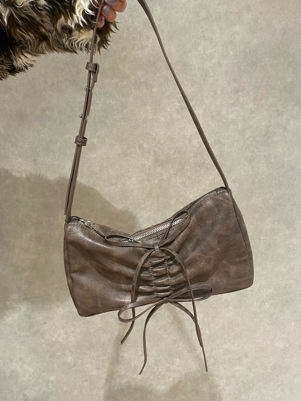 ブラウン系のスカート、ブラウン系のショルダーバッグ、ブラック系のブーツを着用したレディースの秋コーディネートの8枚目の写真