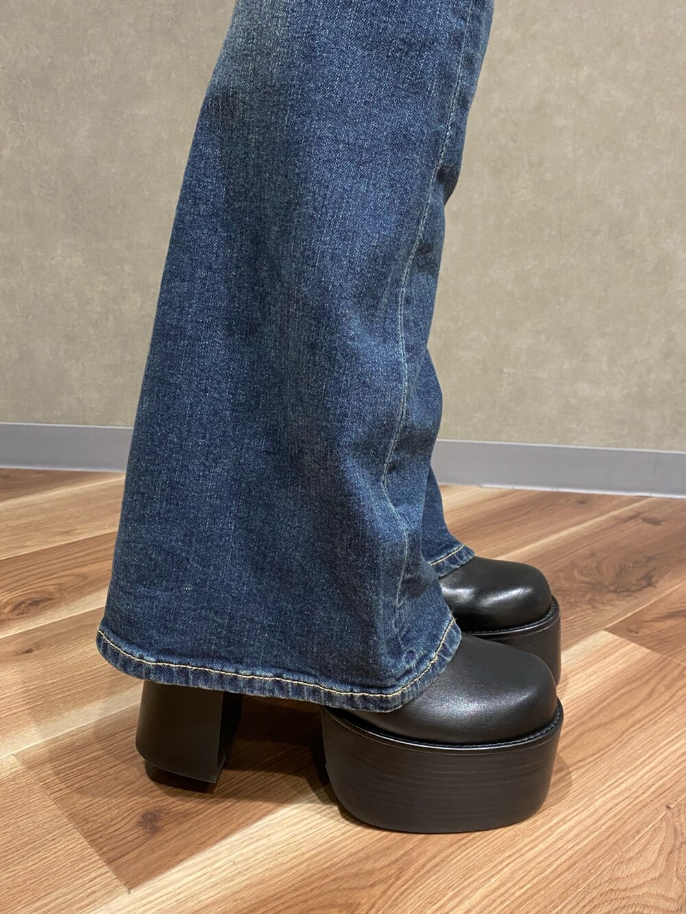 ブラック系のニット/セーター、ブルー系のデニムパンツ、ブラック系のブーツを着用したレディースの秋コーディネートの9枚目の写真