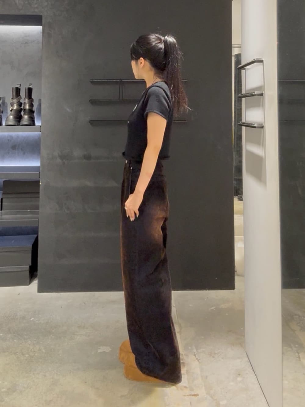 ブラック系のニット/セーター、ブラウン系のデニムパンツ、イエロー系のスリッポンを着用したレディースの夏コーディネートの2枚目の写真