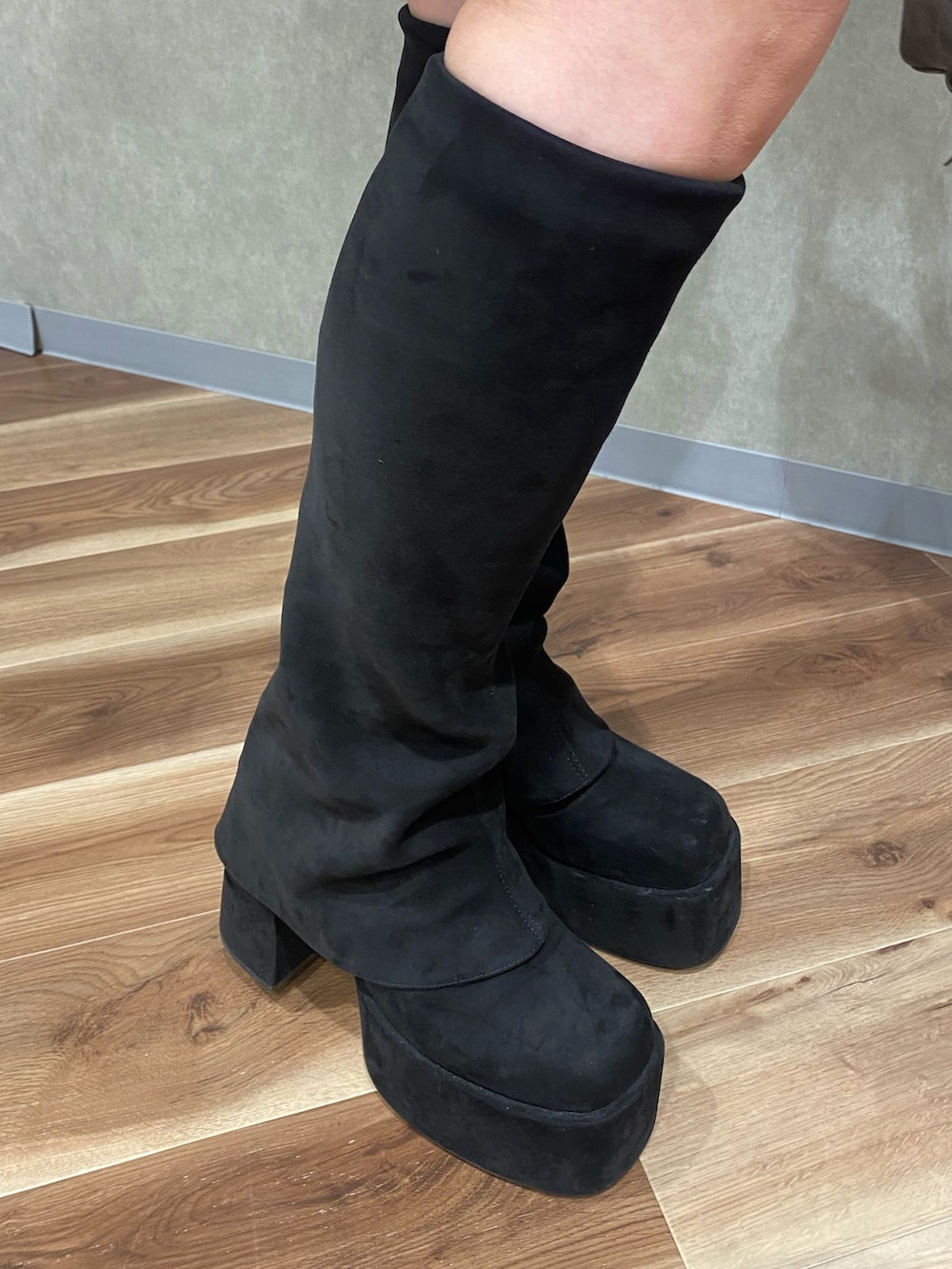 ブラウン系のスカート、ブラウン系のショルダーバッグ、ブラック系のブーツを着用したレディースの秋コーディネートの7枚目の写真