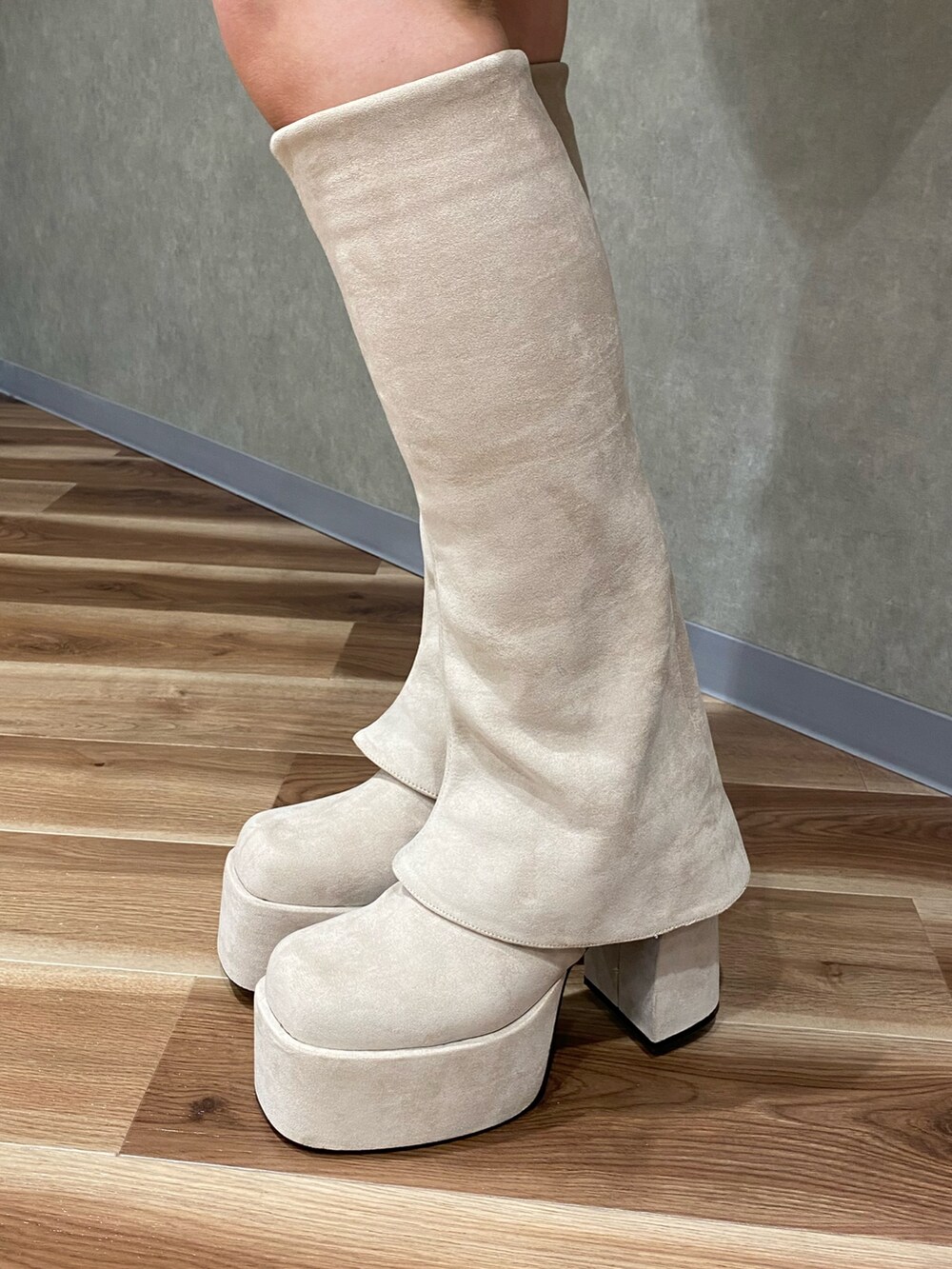 ホワイト系のブルゾン、ブラック系のパーカー、ブラウン系のスカートを着用したレディースの秋コーディネートの7枚目の写真