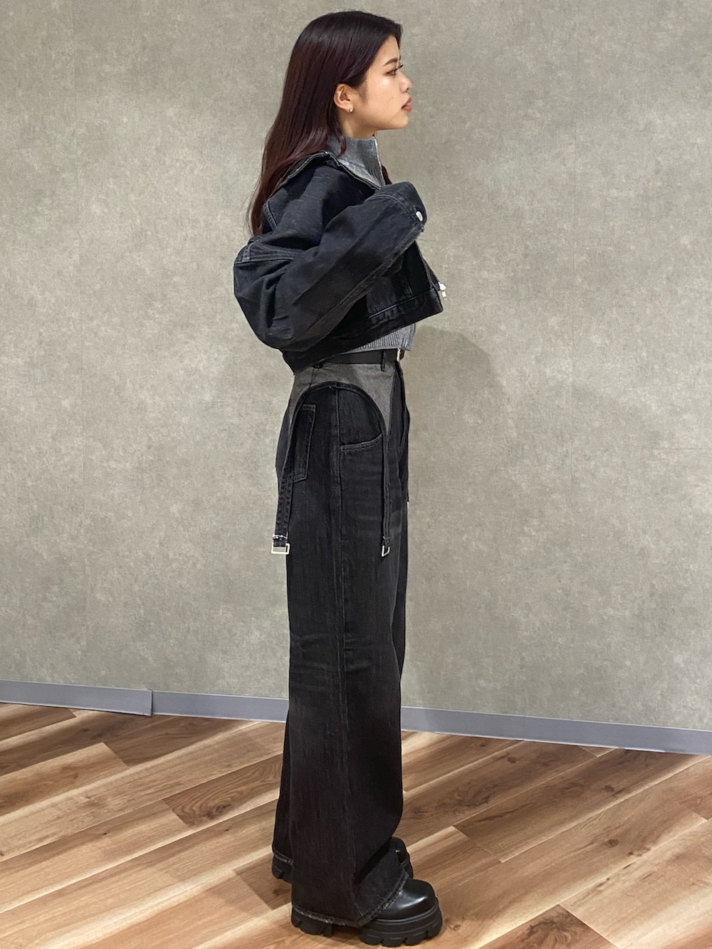 グレー系のニット/セーター、ブラック系のデニムパンツ、ブラック系のブーツを着用したレディースの秋コーディネートの3枚目の写真