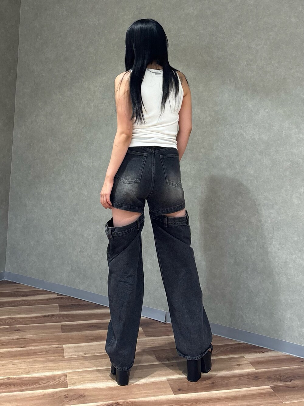ブラック系のデニムパンツ、ブラック系のサンダル、ホワイト系のTシャツ/カットソーを着用したレディースの夏コーディネートの3枚目の写真