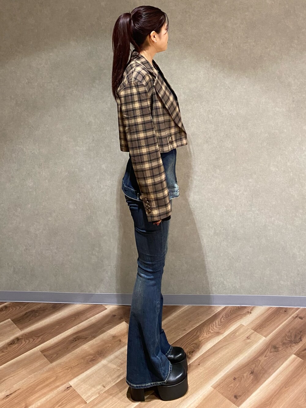 ブラック系のニット/セーター、ブルー系のデニムパンツ、ブラック系のブーツを着用したレディースの秋コーディネートの3枚目の写真