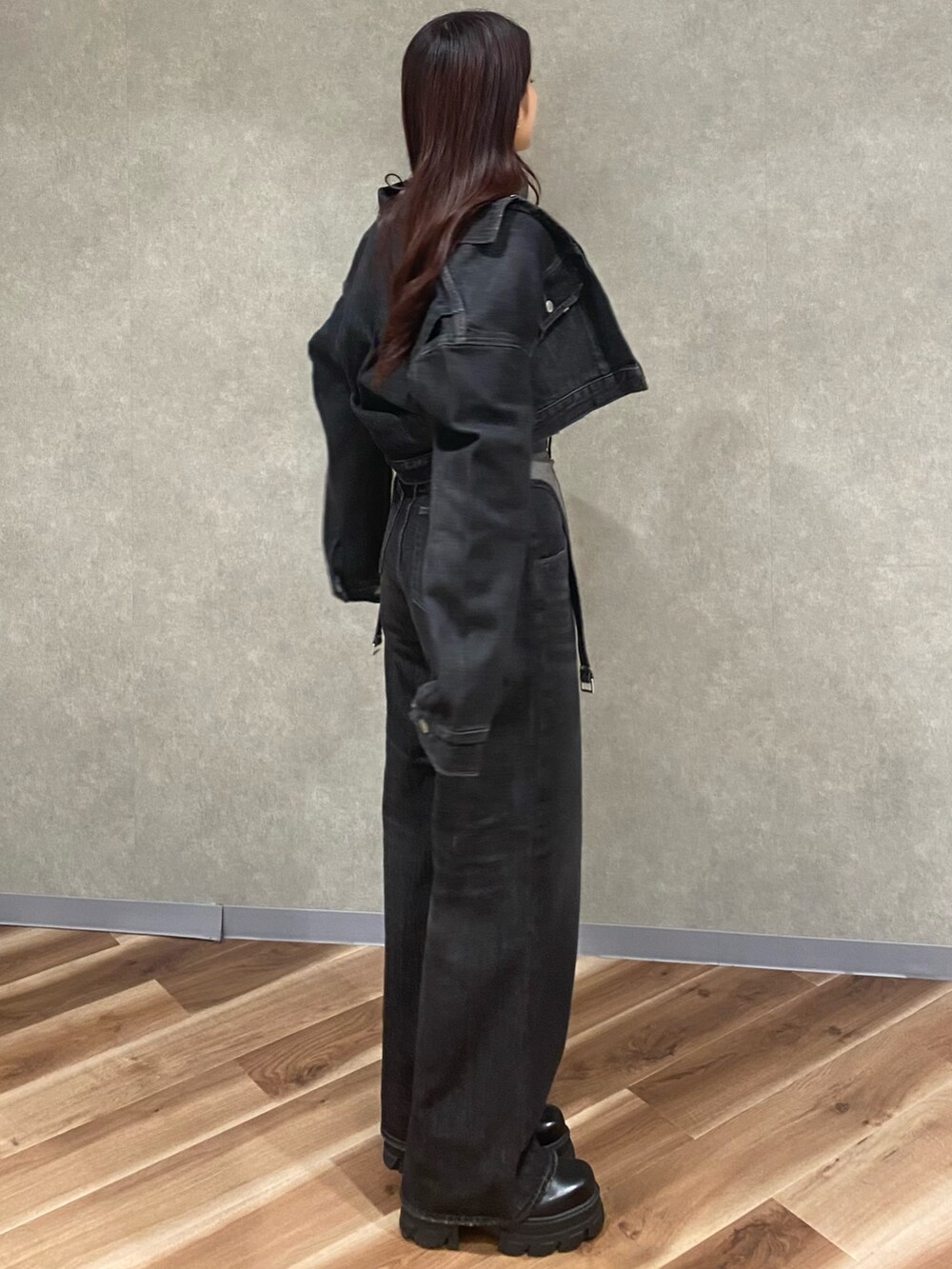 グレー系のニット/セーター、ブラック系のデニムパンツ、ブラック系のブーツを着用したレディースの秋コーディネートの4枚目の写真