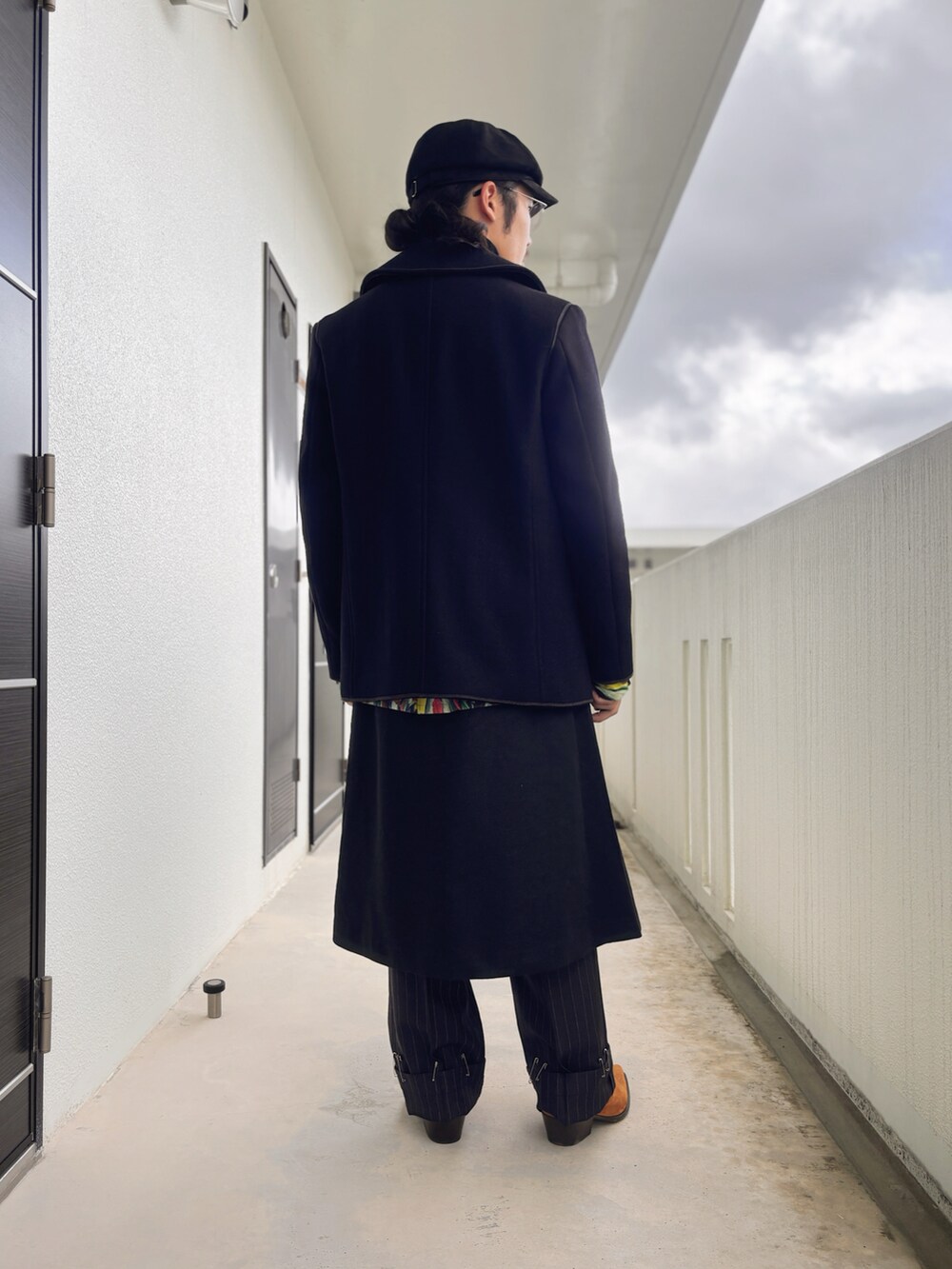 グリーン系のシャツ/ブラウス、ブラック系のニット/セーター、ブラック系のスカートを着用したメンズの冬コーディネートの2枚目の写真