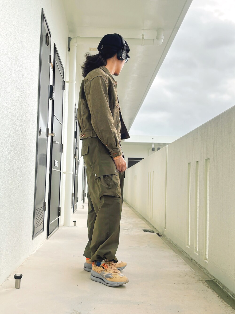 グリーン系のカーゴパンツ、グリーン系のデニムジャケット、ブラウン系のスニーカーを着用したメンズの冬コーディネートの3枚目の写真