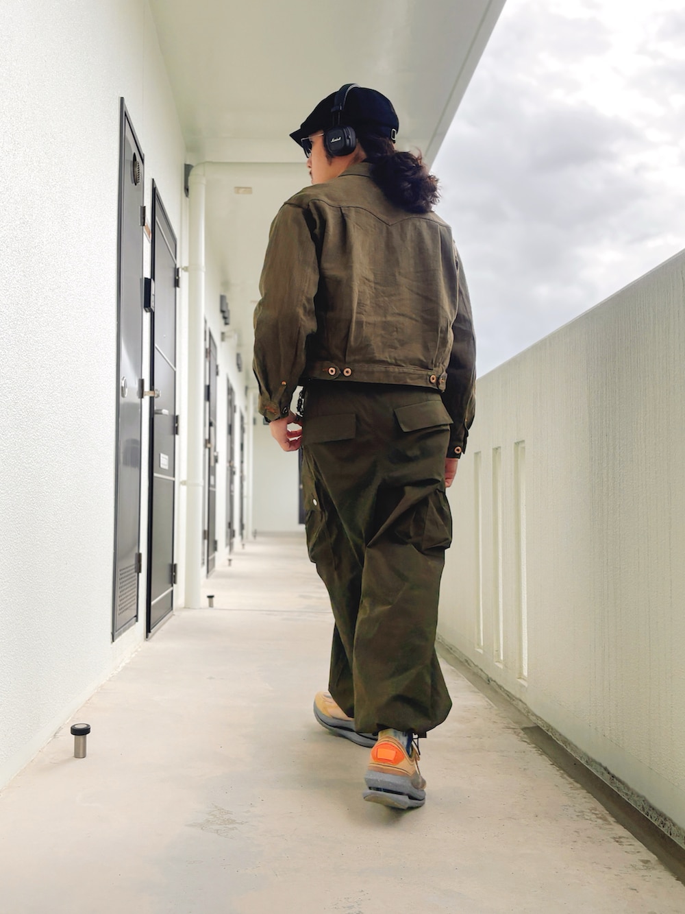 グリーン系のカーゴパンツ、グリーン系のデニムジャケット、ブラウン系のスニーカーを着用したメンズの冬コーディネートの2枚目の写真