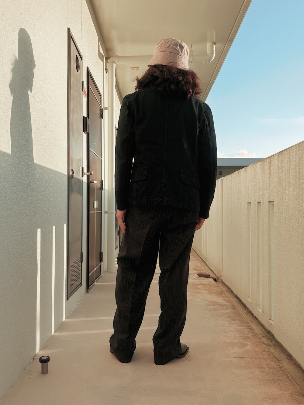 グリーン系のテーラードジャケット、ブラック系のTシャツ/カットソー、ブラック系のスラックスを着用したメンズの秋コーディネートの2枚目の写真