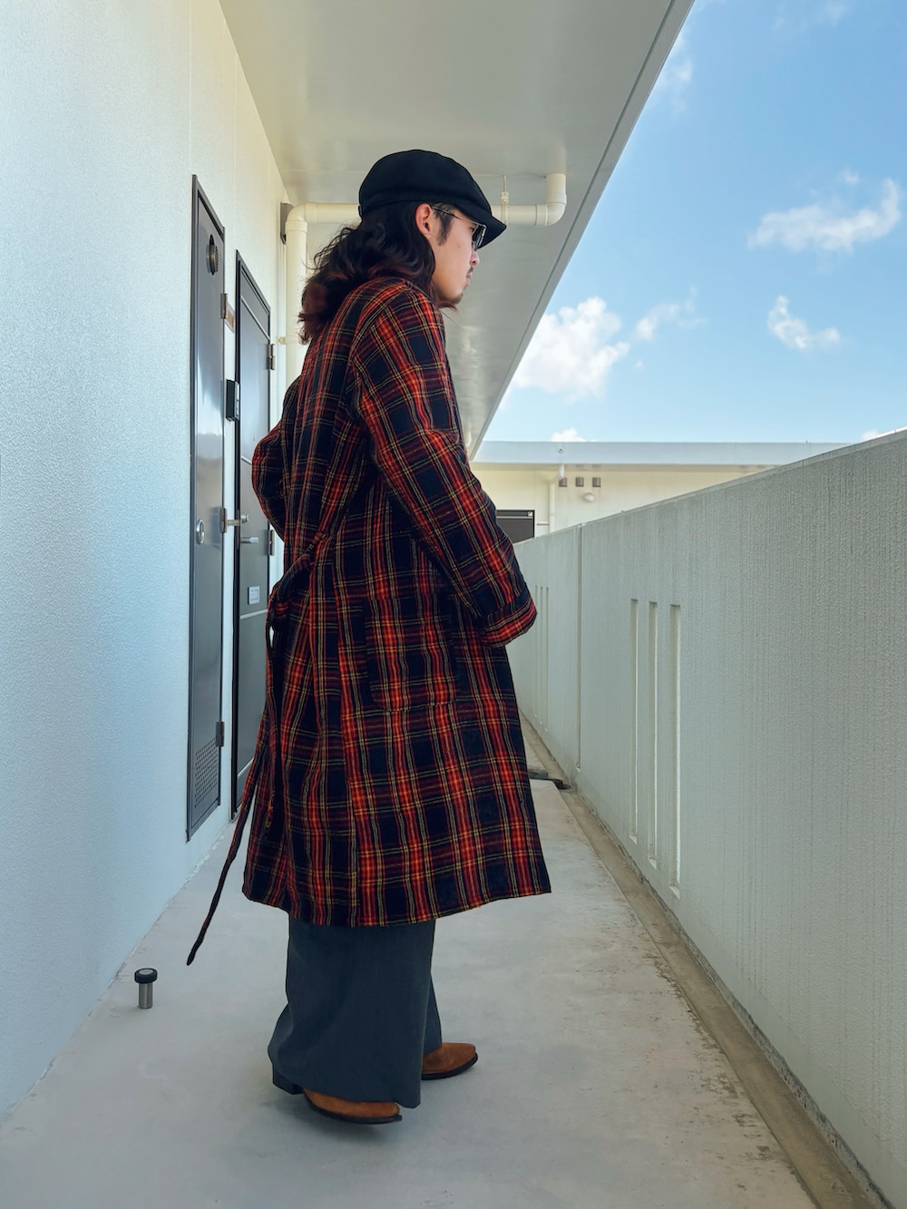 ブラック系のニット/セーター、グレー系のスラックス、ブラウン系のその他シューズを着用したメンズの春コーディネートの2枚目の写真