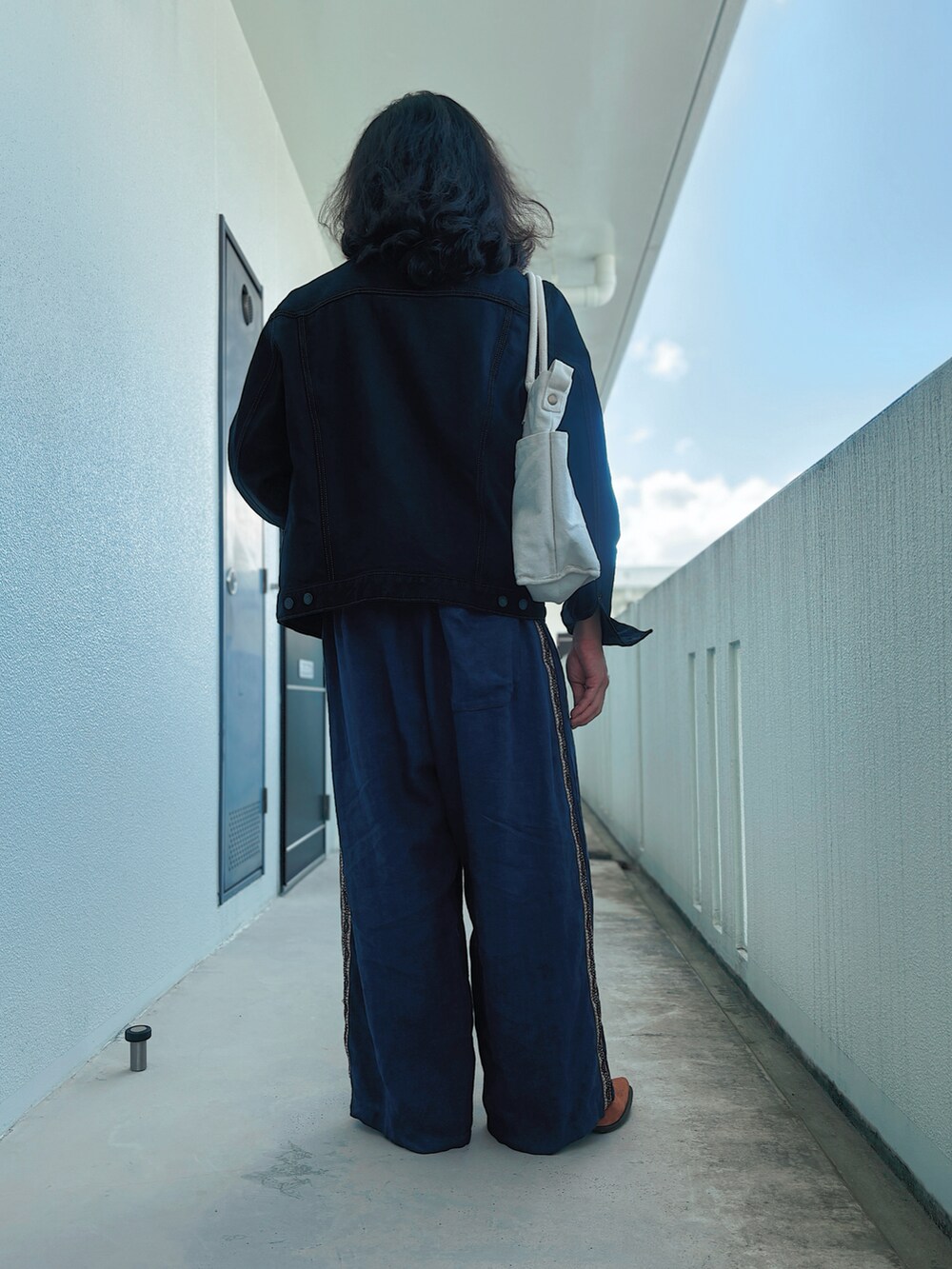 ブラウン系のその他シューズ、ブラック系のデニムジャケット、イエロー系のTシャツ/カットソーを着用したメンズの秋コーディネートの2枚目の写真